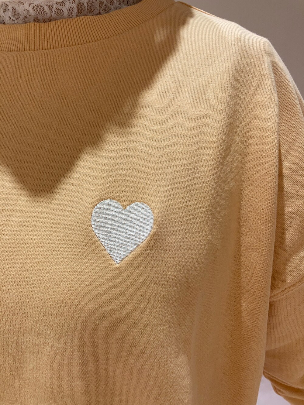 オレンジ系のTシャツ/カットソー、グレー系のスカート、ホワイト系のTシャツ/カットソーを着用したレディースの冬コーディネートの5枚目の写真