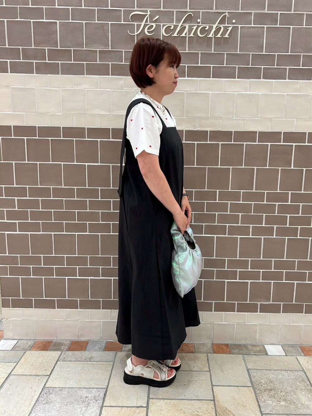 ブラック系のワンピース/ドレス、レッド系のTシャツ/カットソー、シルバー系のハンドバッグを着用したレディースの春コーディネートの3枚目の写真