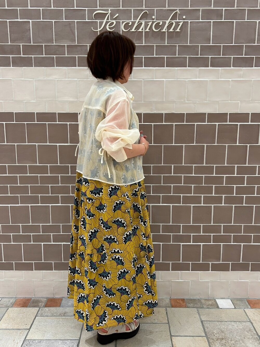 イエロー系のワンピース/ドレス、ホワイト系のシャツ/ブラウスを着用したレディースの春コーディネートの3枚目の写真