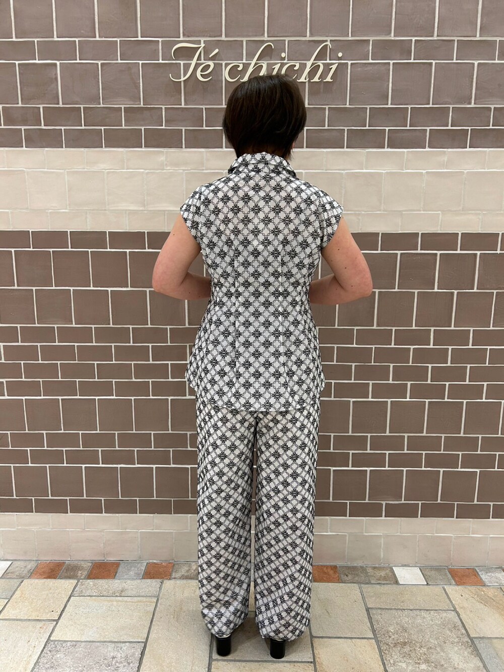 ホワイト系のシャツ/ブラウス、ホワイト系のパンツ、ブラック系のサンダルを着用したレディースの夏コーディネートの4枚目の写真