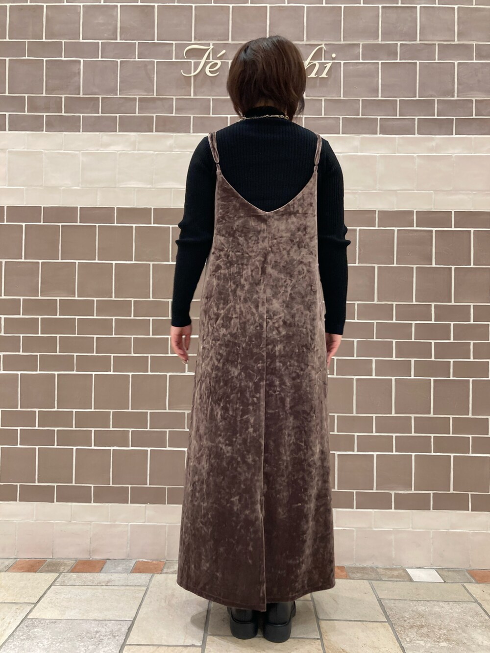 ブラック系のニット/セーター、ブラウン系のワンピース/ドレス、ブラック系のシューズを着用したレディースの冬コーディネートの3枚目の写真