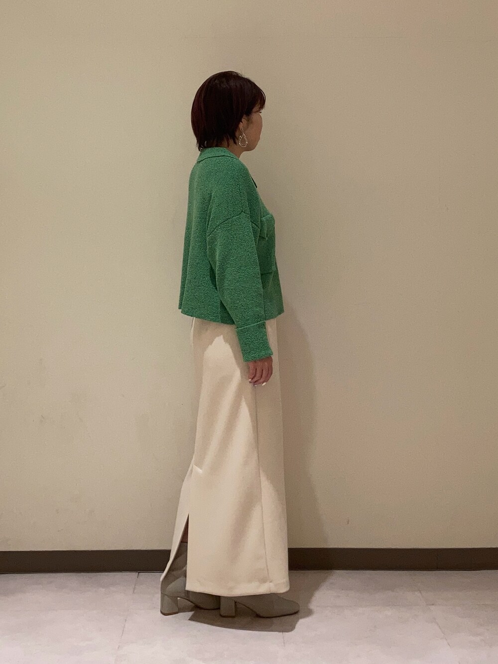 グリーン系のカーディガン/ボレロ、ベージュ系のスカートを着用したレディースの冬コーディネートの3枚目の写真