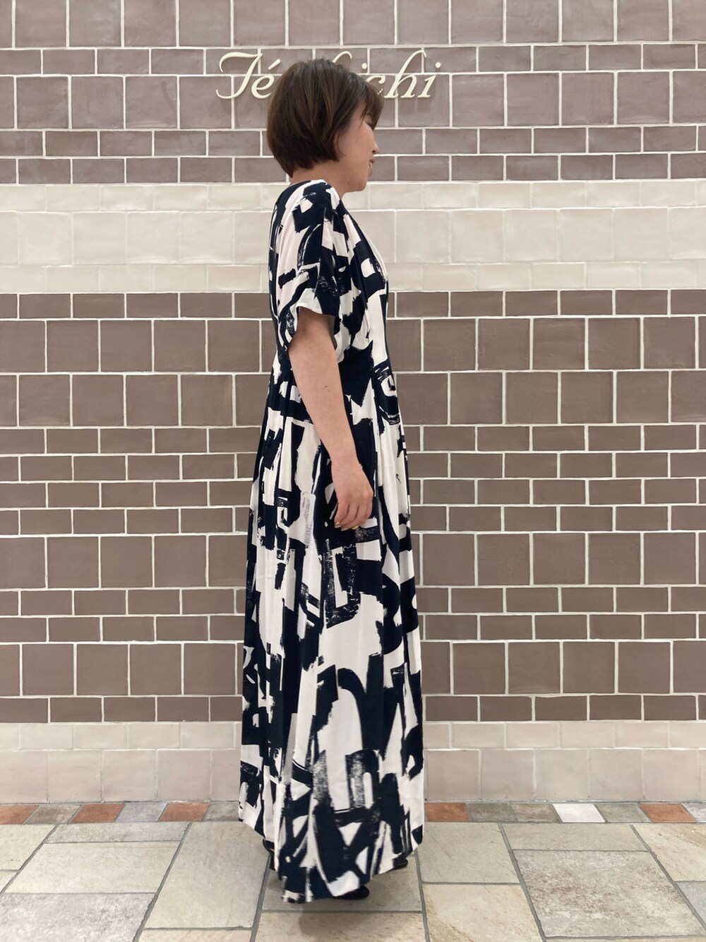 ブラック系のワンピース/ドレス、シルバー系のハンドバッグ、ブラック系のサンダルを着用したレディースの春コーディネートの3枚目の写真