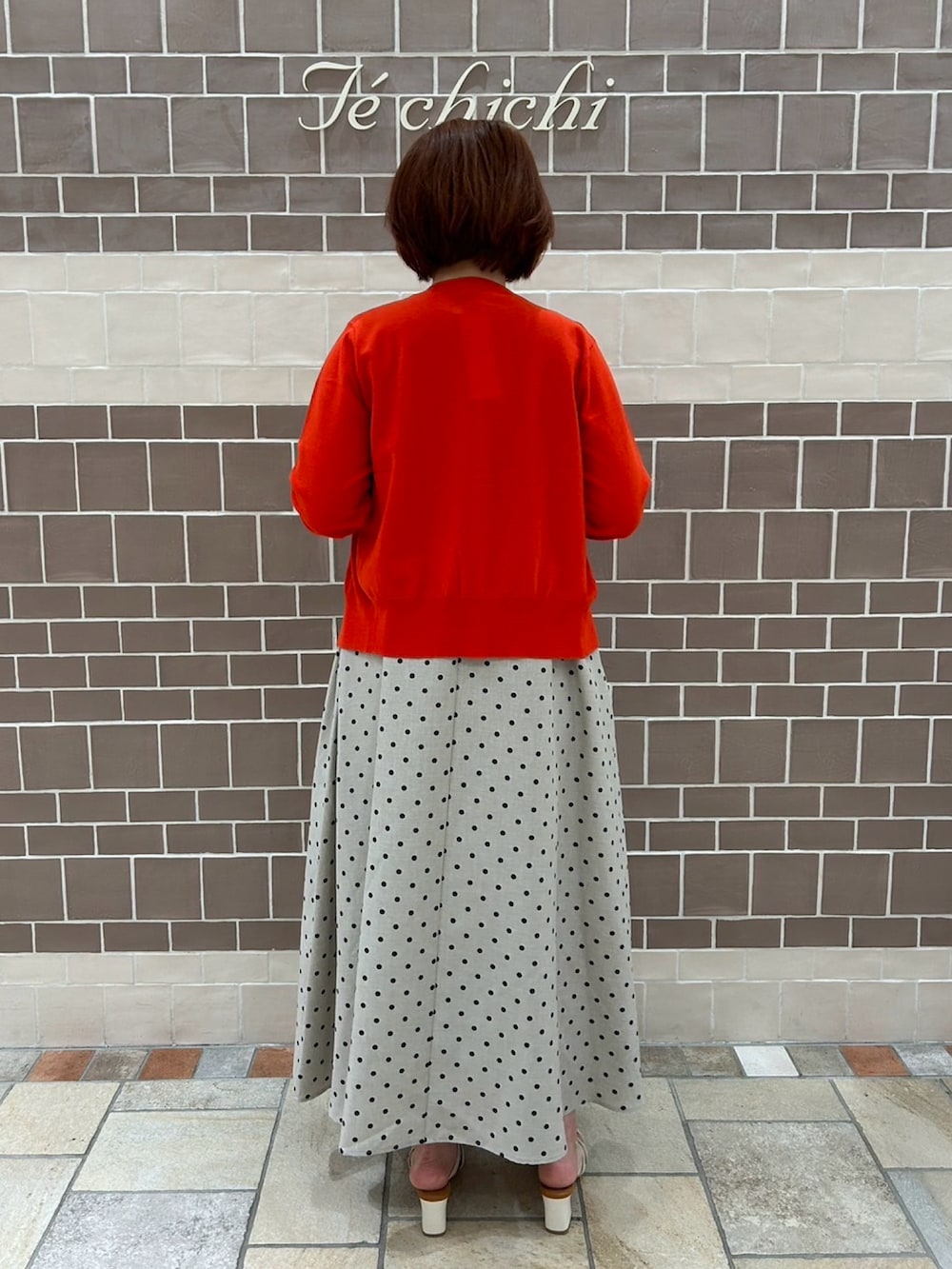 ベージュ系のワンピース/ドレス、レッド系のカーディガン/ボレロ、ホワイト系のサンダルを着用したレディースの夏コーディネートの5枚目の写真