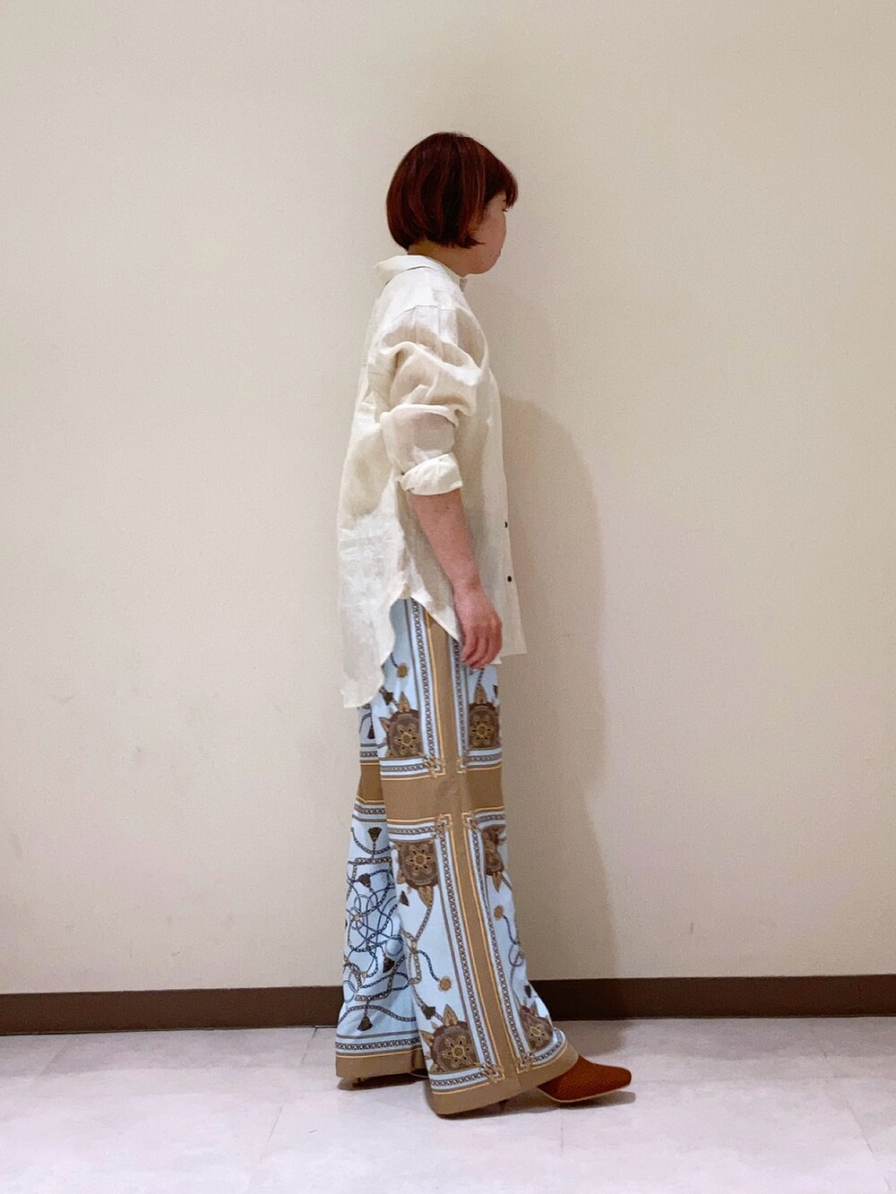 ホワイト系のシャツ/ブラウス、ベージュ系のパンツを着用したレディースの春コーディネートの2枚目の写真