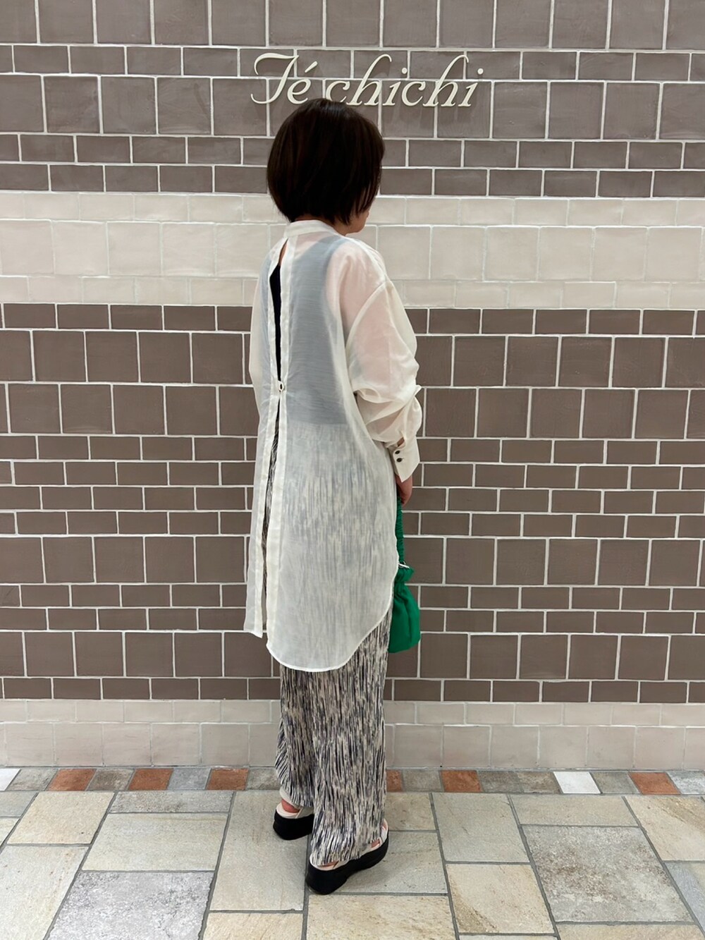 ホワイト系のシャツ/ブラウス、ホワイト系のその他パンツ、グリーン系のハンドバッグを着用したレディースの春コーディネートの4枚目の写真