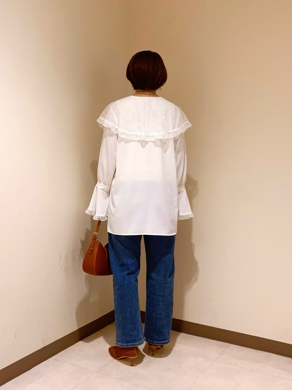 ホワイト系のシャツ/ブラウス、ブラウン系のハンドバッグ、ブラウン系のパンプスを着用したレディースの春コーディネートの3枚目の写真