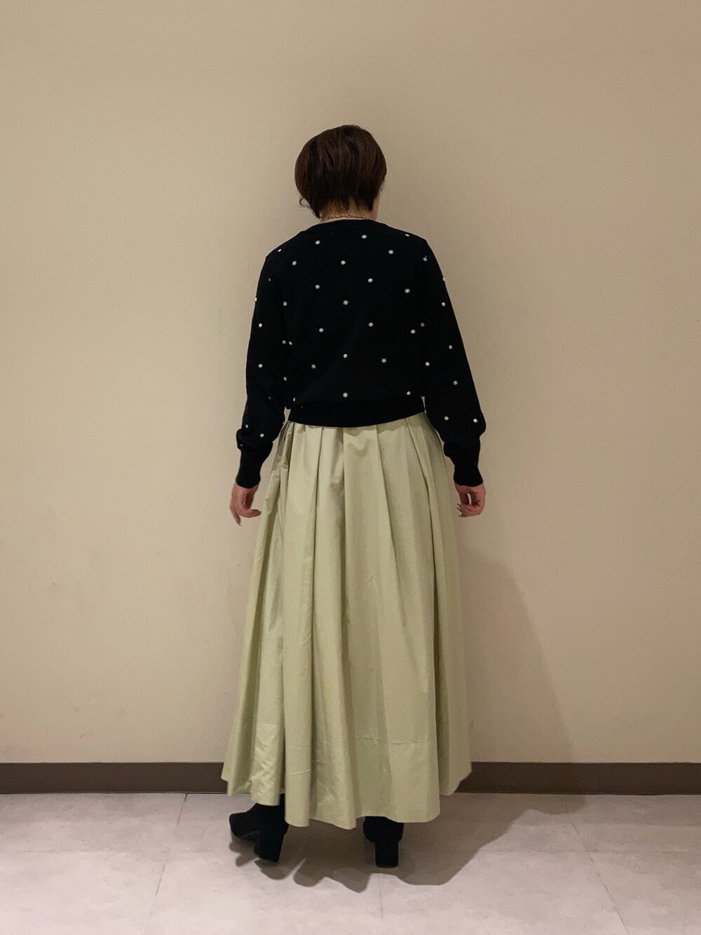 ブラック系のカーディガン/ボレロ、グリーン系のスカートを着用したレディースの冬コーディネートの3枚目の写真