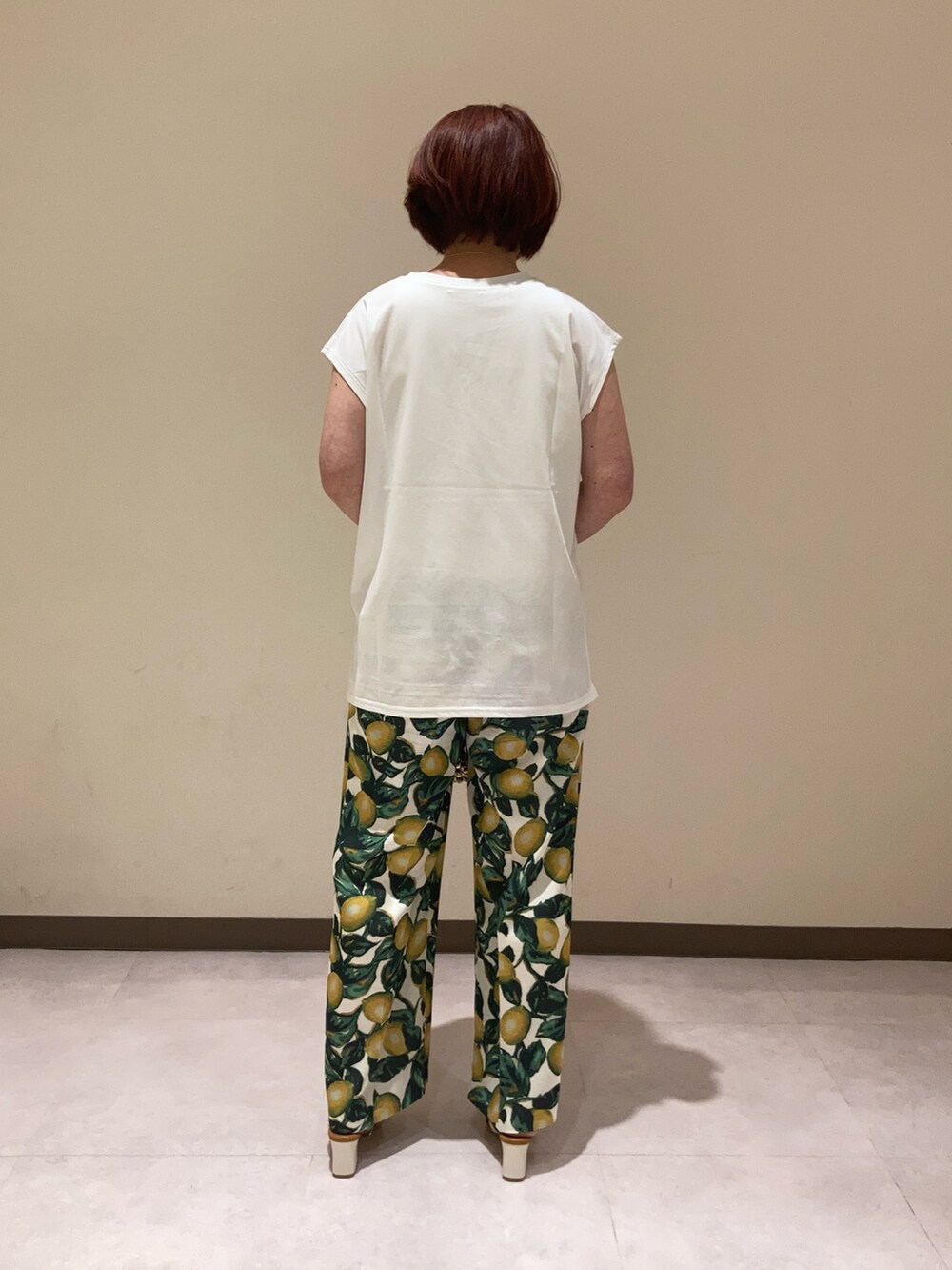 ホワイト系のTシャツ/カットソー、ホワイト系のその他パンツ、ゴールド系のハンドバッグを着用したレディースの夏コーディネートの2枚目の写真