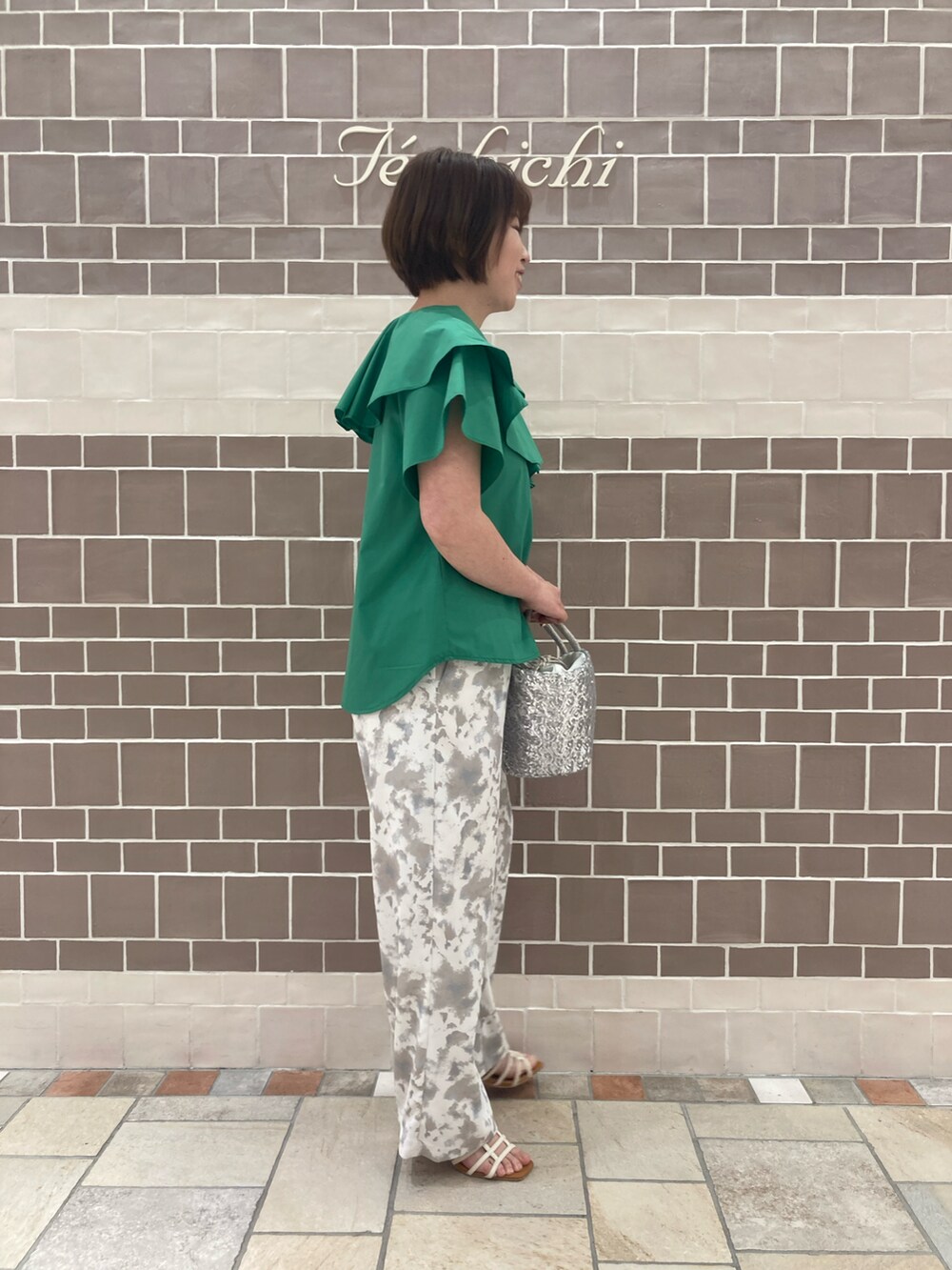 グリーン系のシャツ/ブラウス、シルバー系のハンドバッグ、ベージュ系のその他パンツを着用したレディースの春コーディネートの3枚目の写真