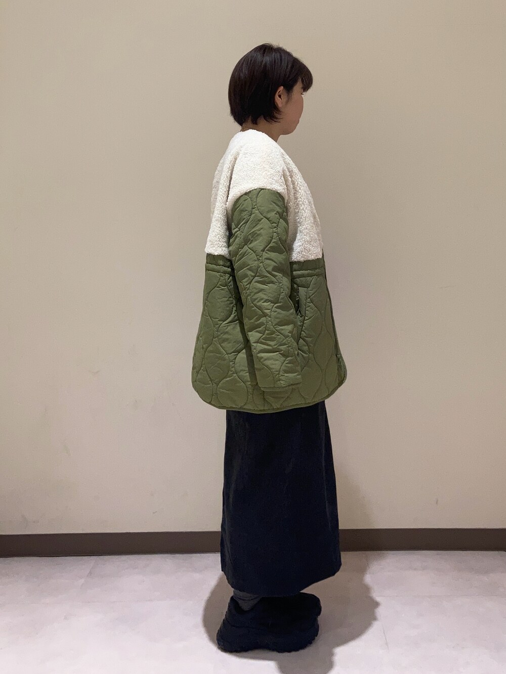 ブラック系のワンピース、グリーン系のその他アウター、ホワイト系のTシャツ/カットソーを着用したレディースの秋コーディネートの2枚目の写真