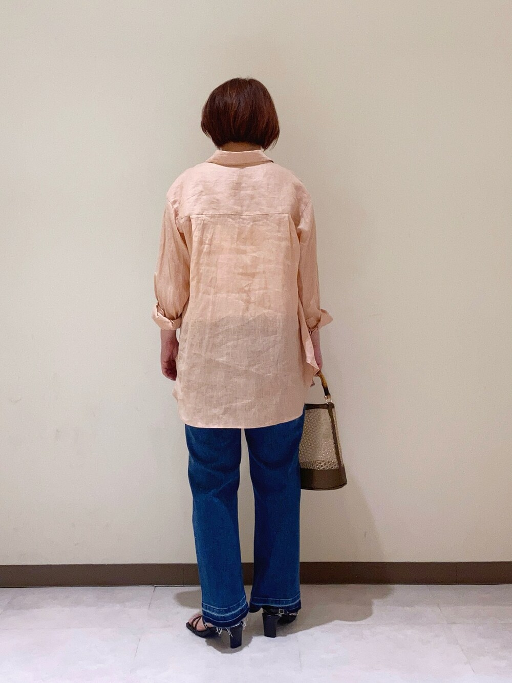 ピンク系のシャツ/ブラウス、ブラウン系のハンドバッグ、ブラウン系のサンダルを着用したレディースの春コーディネートの3枚目の写真