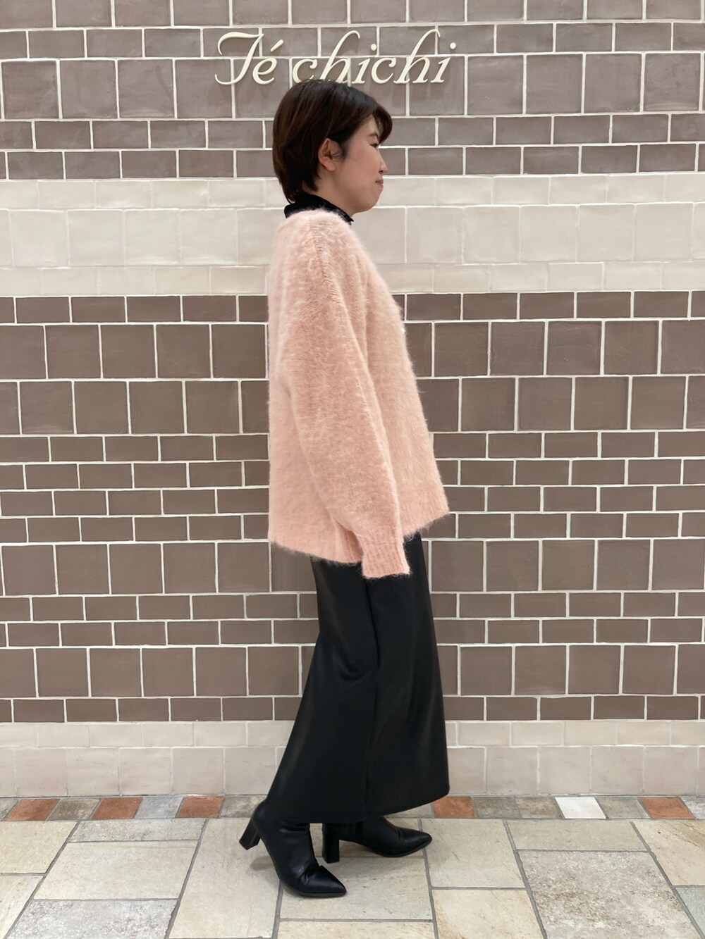 ピンク系のカーディガン/ボレロ、ブラック系のスカートを着用したレディースの冬コーディネートの3枚目の写真