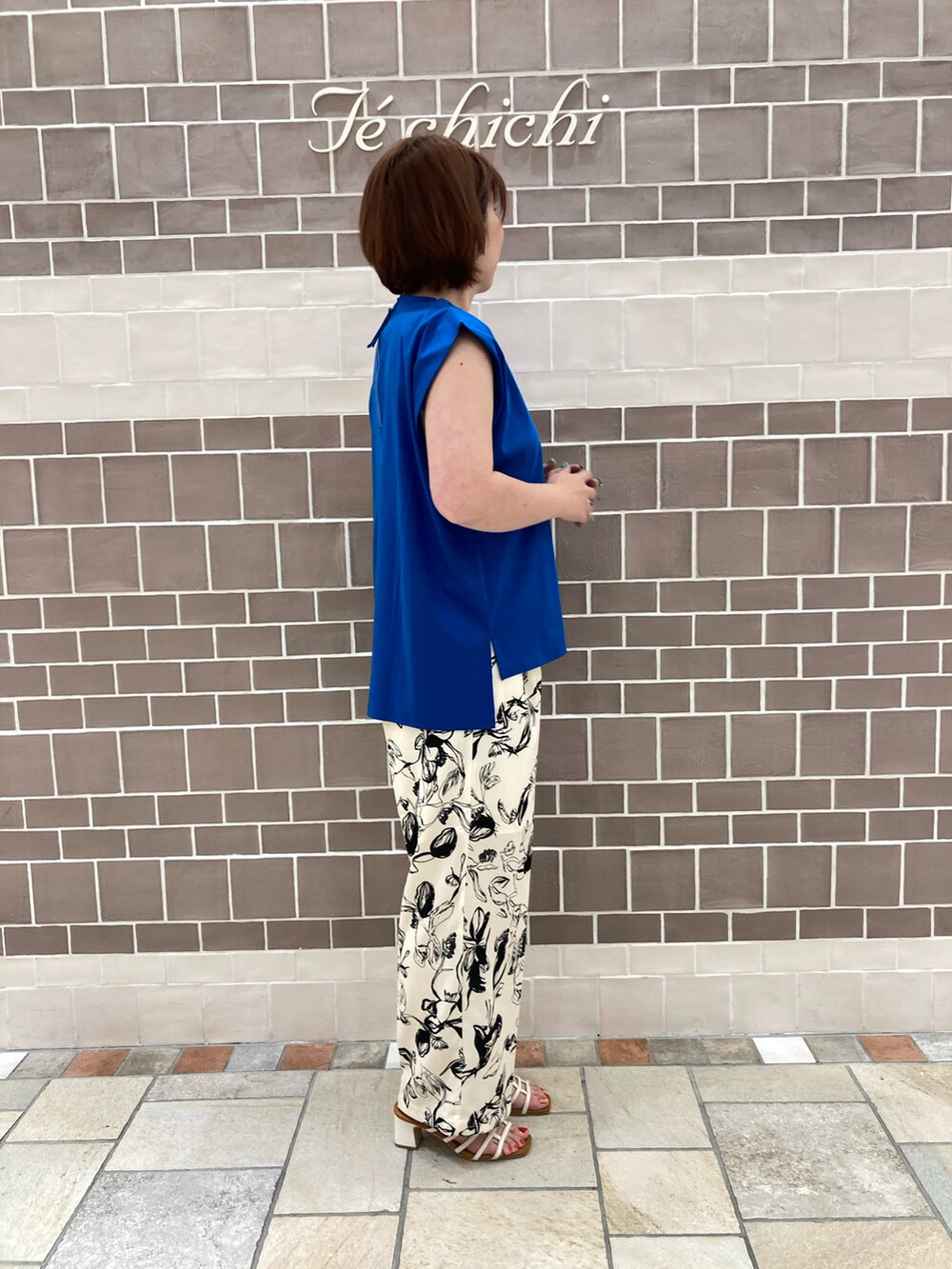 ブルー系のTシャツ/カットソー、ホワイト系のパンツを着用したレディースの夏コーディネートの2枚目の写真