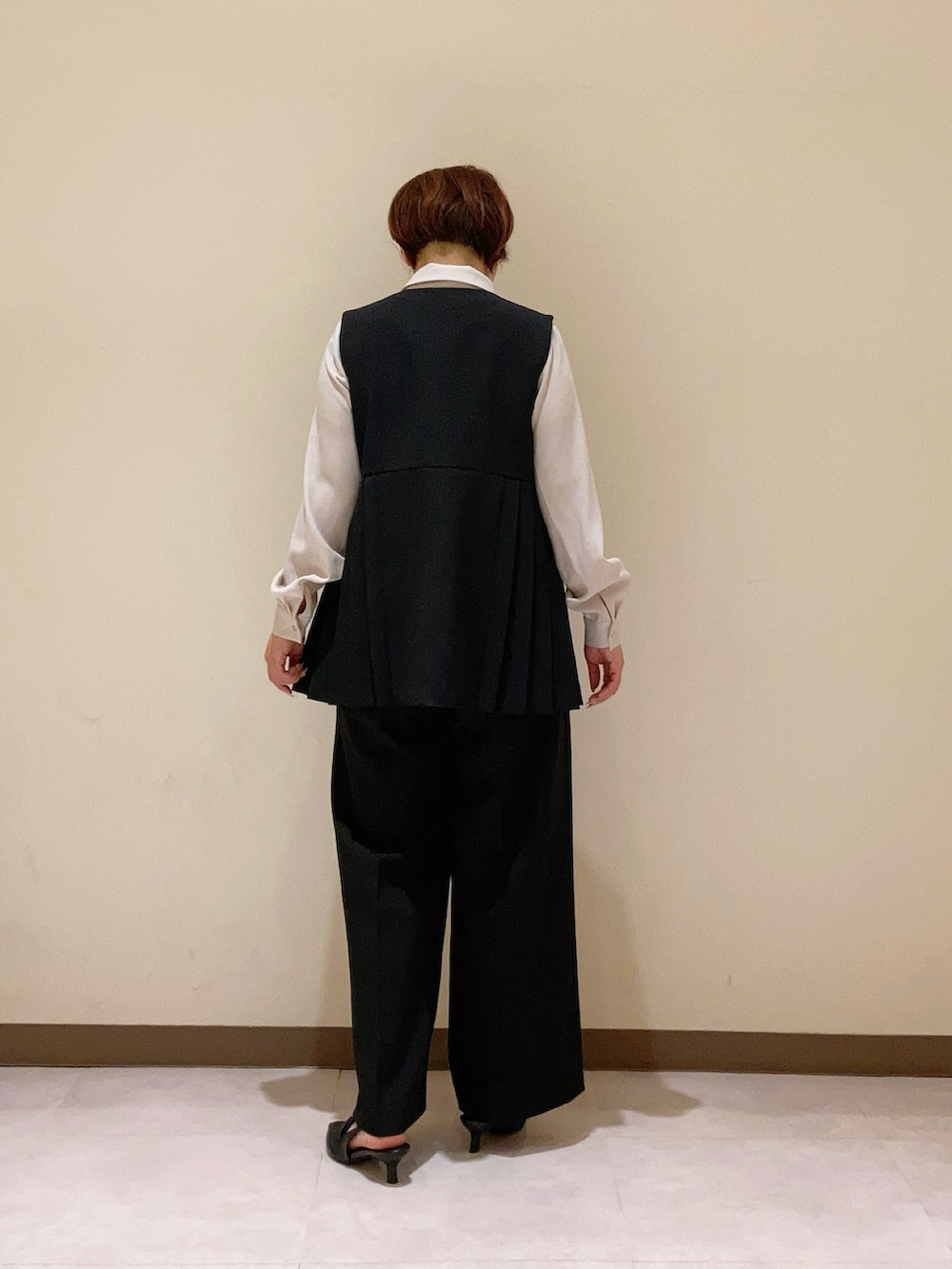 ブラック系のベスト、グレー系のシャツ/ブラウスを着用したレディースの春コーディネートの3枚目の写真