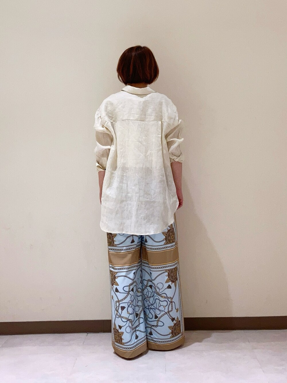 ホワイト系のシャツ/ブラウス、ベージュ系のパンツを着用したレディースの春コーディネートの3枚目の写真