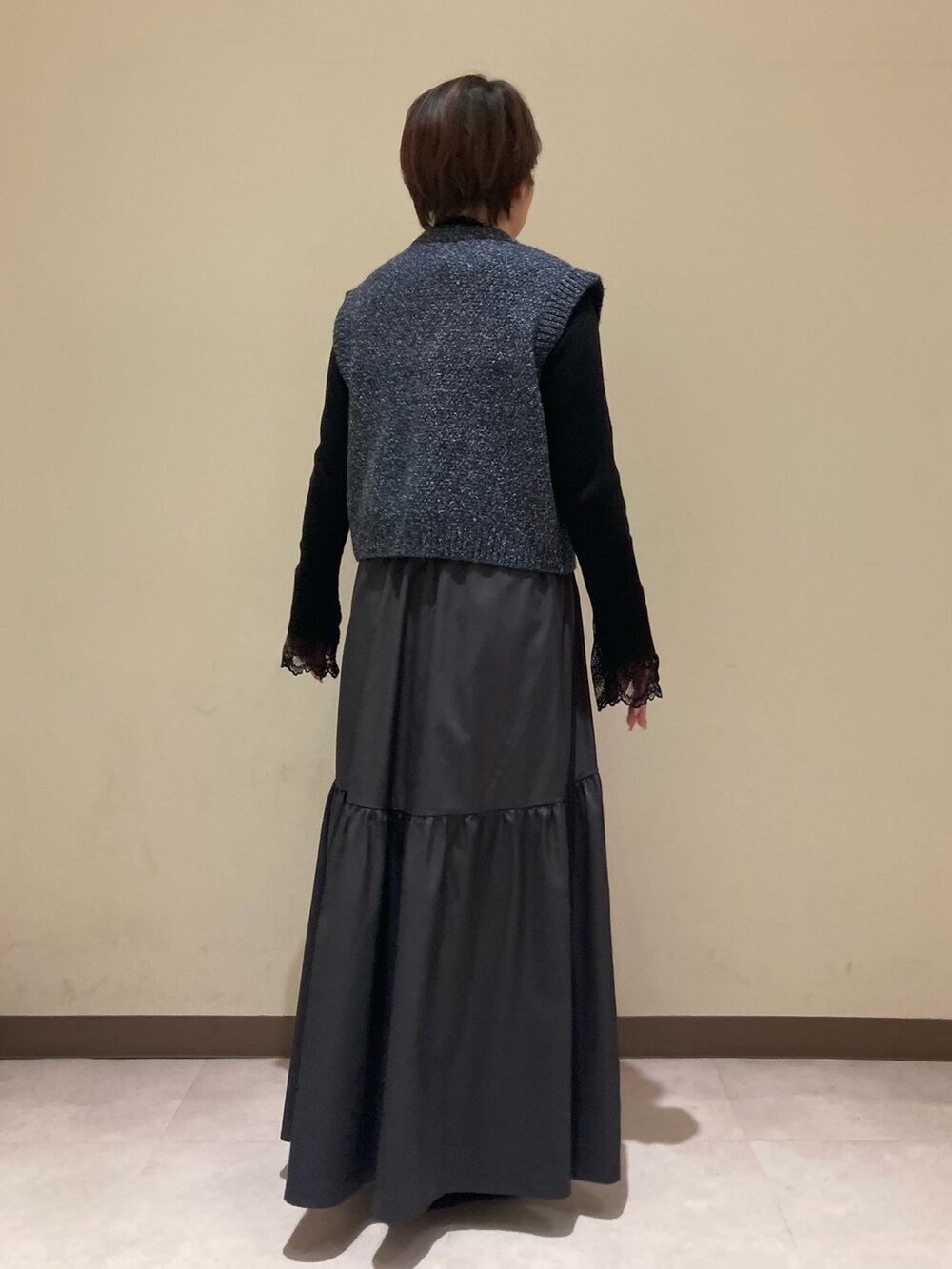 ブルー系のベスト、ブラック系のニット/セーター、グレー系のスカートを着用したレディースの冬コーディネートの3枚目の写真