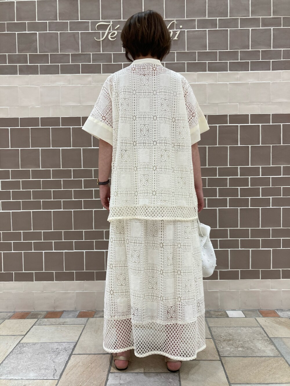 ホワイト系のシャツ/ブラウス、ホワイト系のスカート、ホワイト系のハンドバッグを着用したレディースの春コーディネートの3枚目の写真