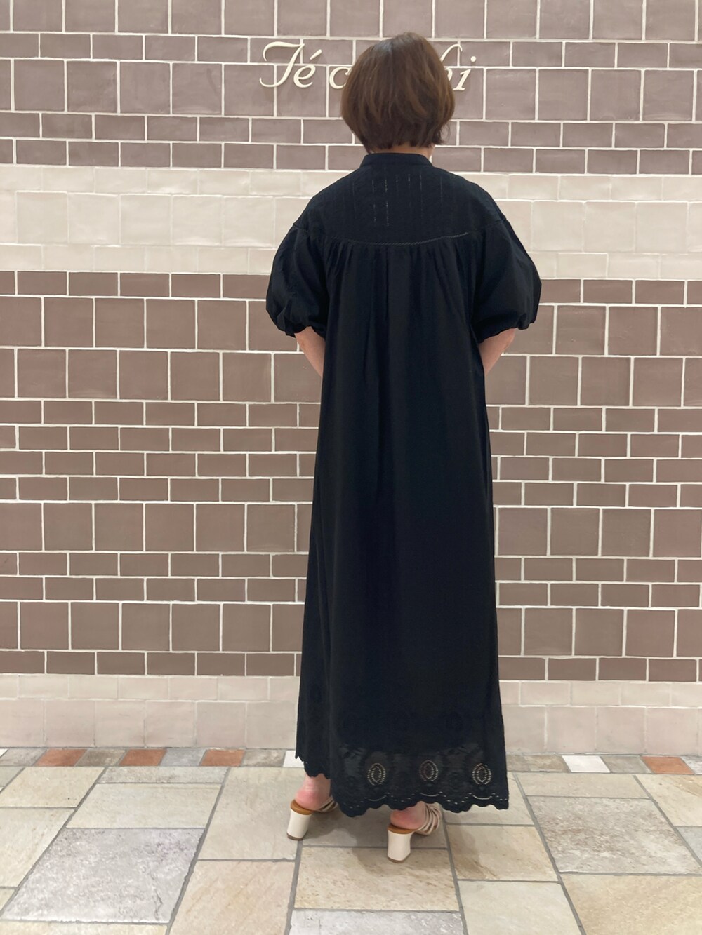 ブラック系のワンピース、ホワイト系のサンダルを着用したレディースの春コーディネートの4枚目の写真