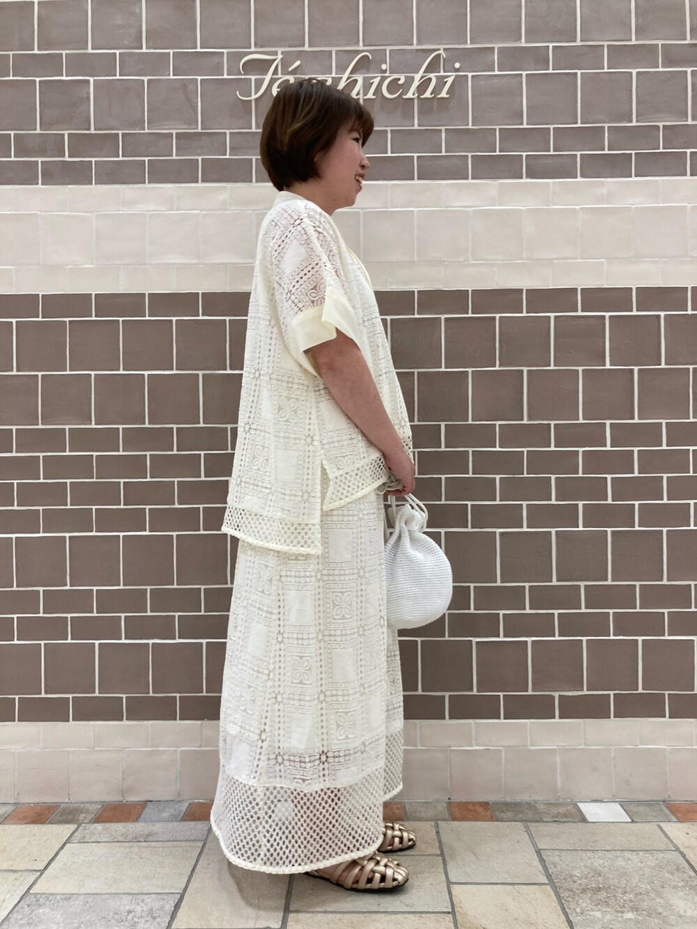 ホワイト系のシャツ/ブラウス、ホワイト系のスカート、ホワイト系のハンドバッグを着用したレディースの春コーディネートの2枚目の写真