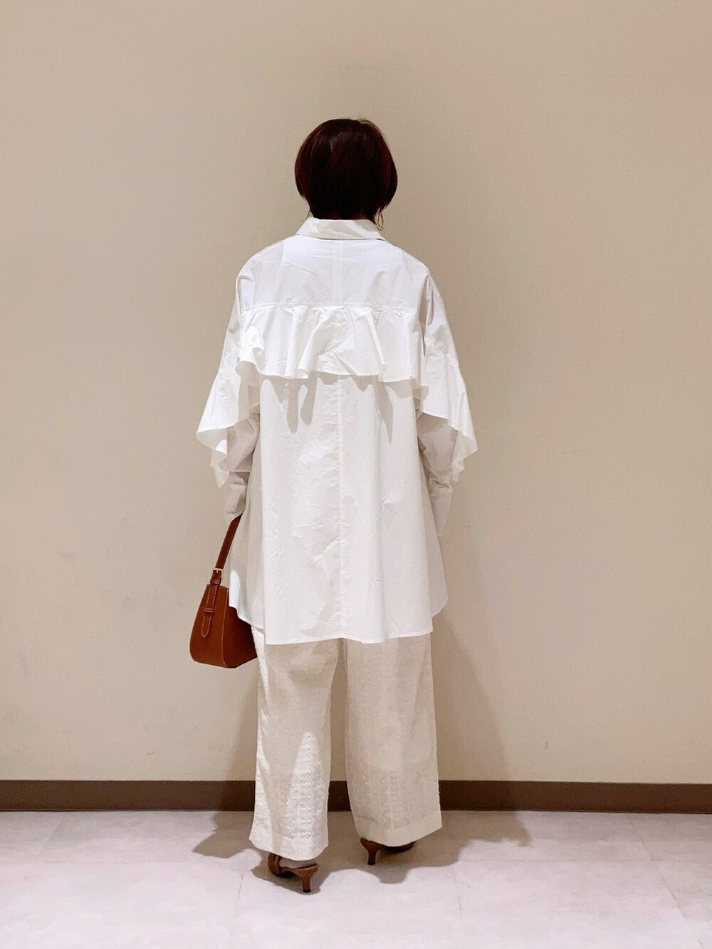 ホワイト系のシャツ/ブラウス、ホワイト系のパンツを着用したレディースの冬コーディネートの4枚目の写真