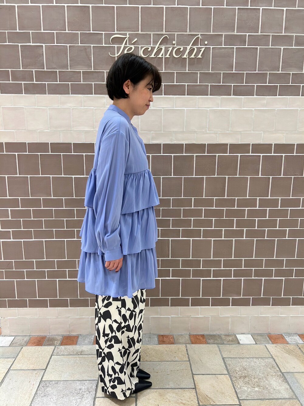 ブルー系のシャツ/ブラウス、ゴールド系のハンドバッグ、ホワイト系のパンツを着用したレディースの冬コーディネートの3枚目の写真