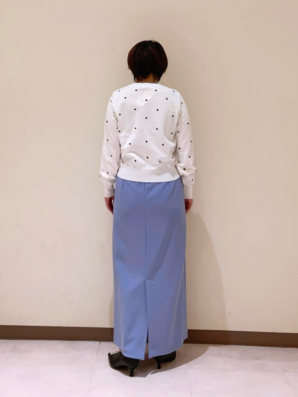 ホワイト系のカーディガン/ボレロ、ブルー系のスカートを着用したレディースの冬コーディネートの2枚目の写真