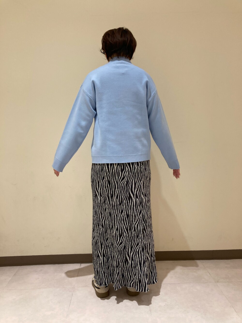 ブルー系のニット/セーター、ブラック系のスカートを着用したレディースの冬コーディネートの4枚目の写真