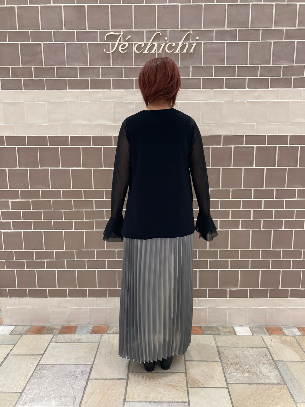 ブラック系のTシャツ/カットソー、グレー系のスカートを着用したレディースの秋コーディネートの3枚目の写真