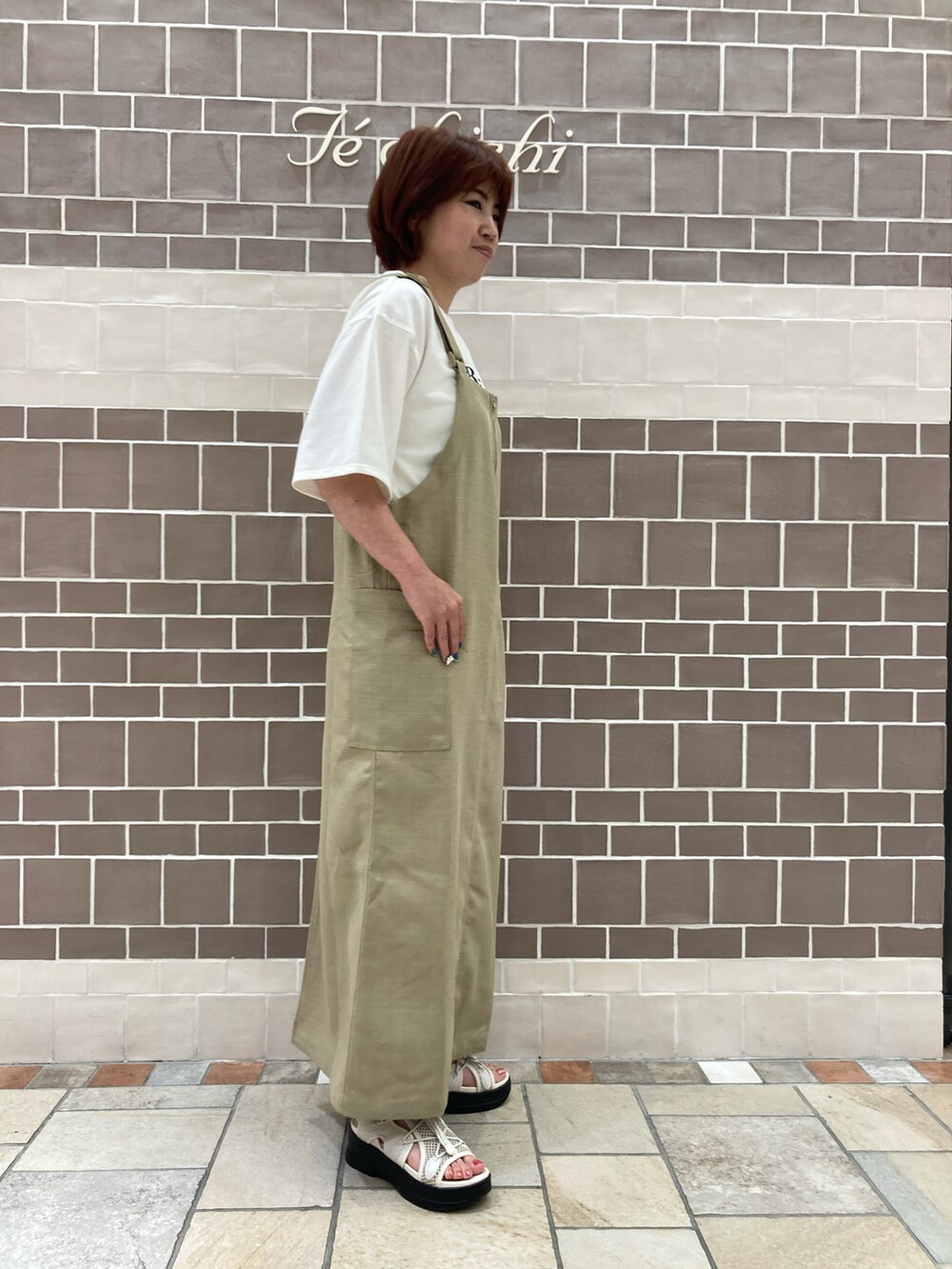 ベージュ系のワンピース、ホワイト系のTシャツ/カットソーを着用したレディースの夏コーディネートの3枚目の写真