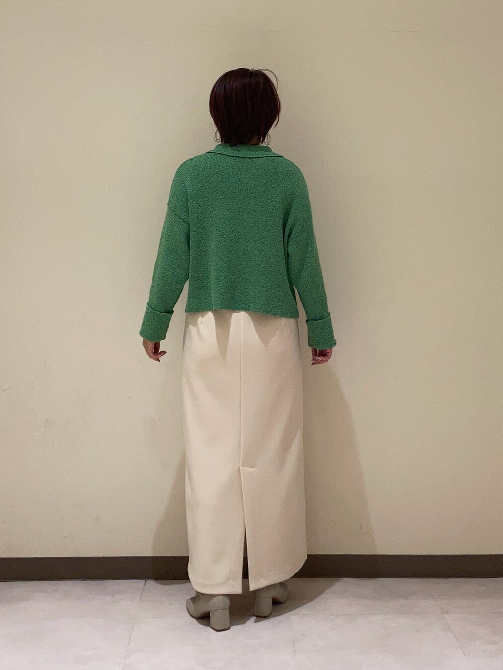 グリーン系のカーディガン/ボレロ、ベージュ系のスカートを着用したレディースの冬コーディネートの4枚目の写真