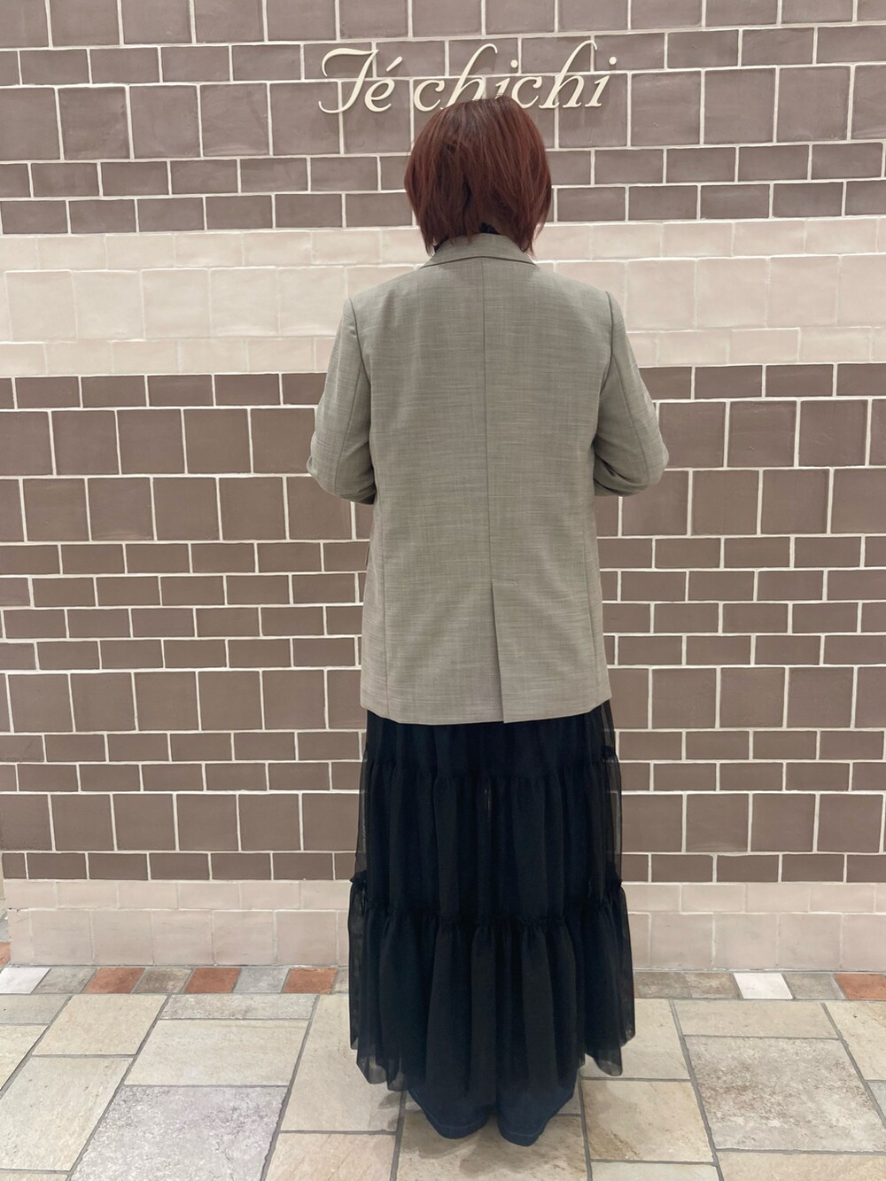 ベージュ系のノーカラージャケット、ブラック系のワンピース/ドレス、ブルー系のデニムパンツを着用したレディースの秋コーディネートの4枚目の写真