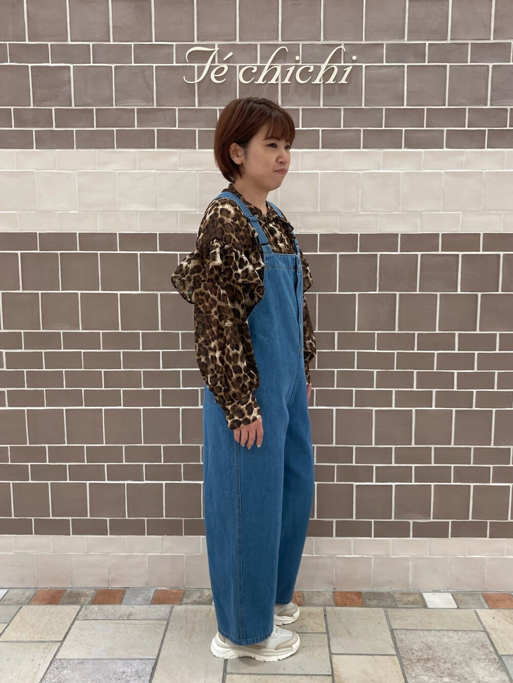 ブルー系のサロペット/オーバーオール、ブラウン系のシャツ/ブラウス、ブラウン系のスニーカーを着用したレディースの夏コーディネートの2枚目の写真