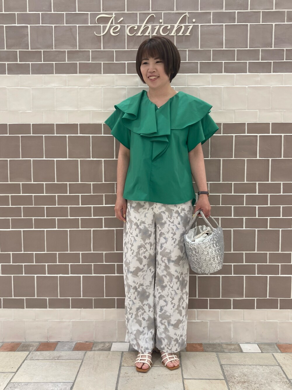 グリーン系のシャツ/ブラウス、シルバー系のハンドバッグ、ベージュ系のその他パンツを着用したレディースの春コーディネートの2枚目の写真