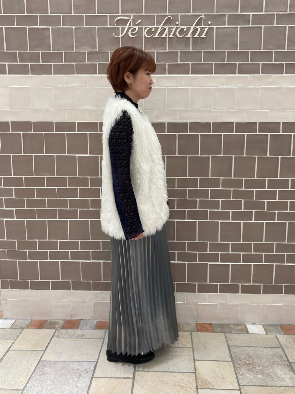 グレー系のスカートを着用したレディースの秋コーディネートの3枚目の写真