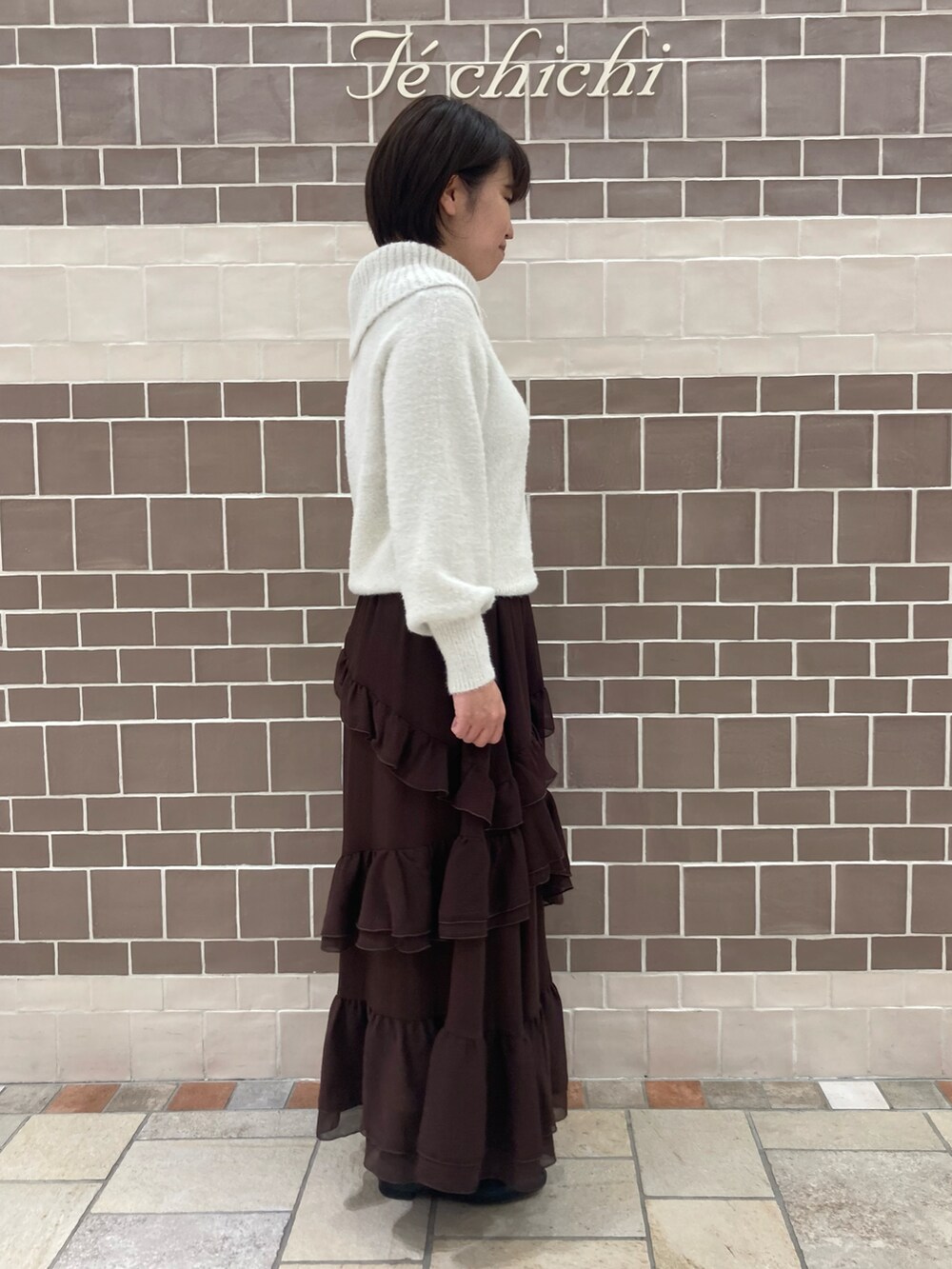 ホワイト系のニット/セーター、ブラウン系のスカートを着用したレディースの秋コーディネートの3枚目の写真