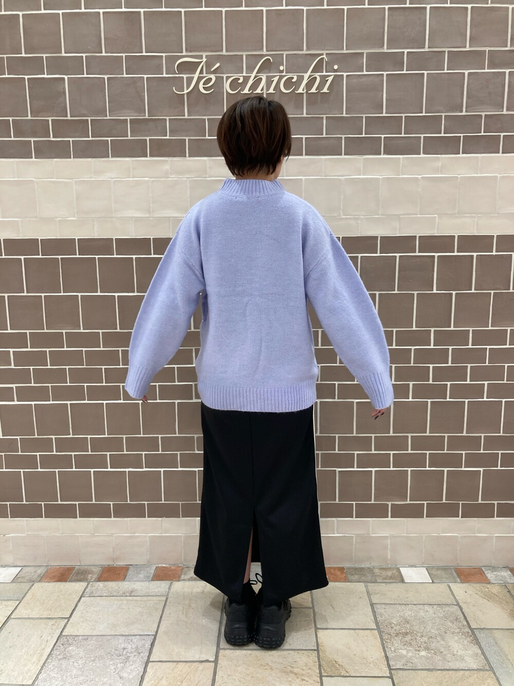 パープル系のニット/セーター、ブラック系のスカートを着用したレディースの冬コーディネートの4枚目の写真