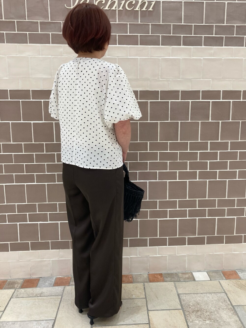 ホワイト系のシャツ/ブラウス、ブラック系のハンドバッグ、ブラウン系のパンツを着用したレディースの春コーディネートの2枚目の写真