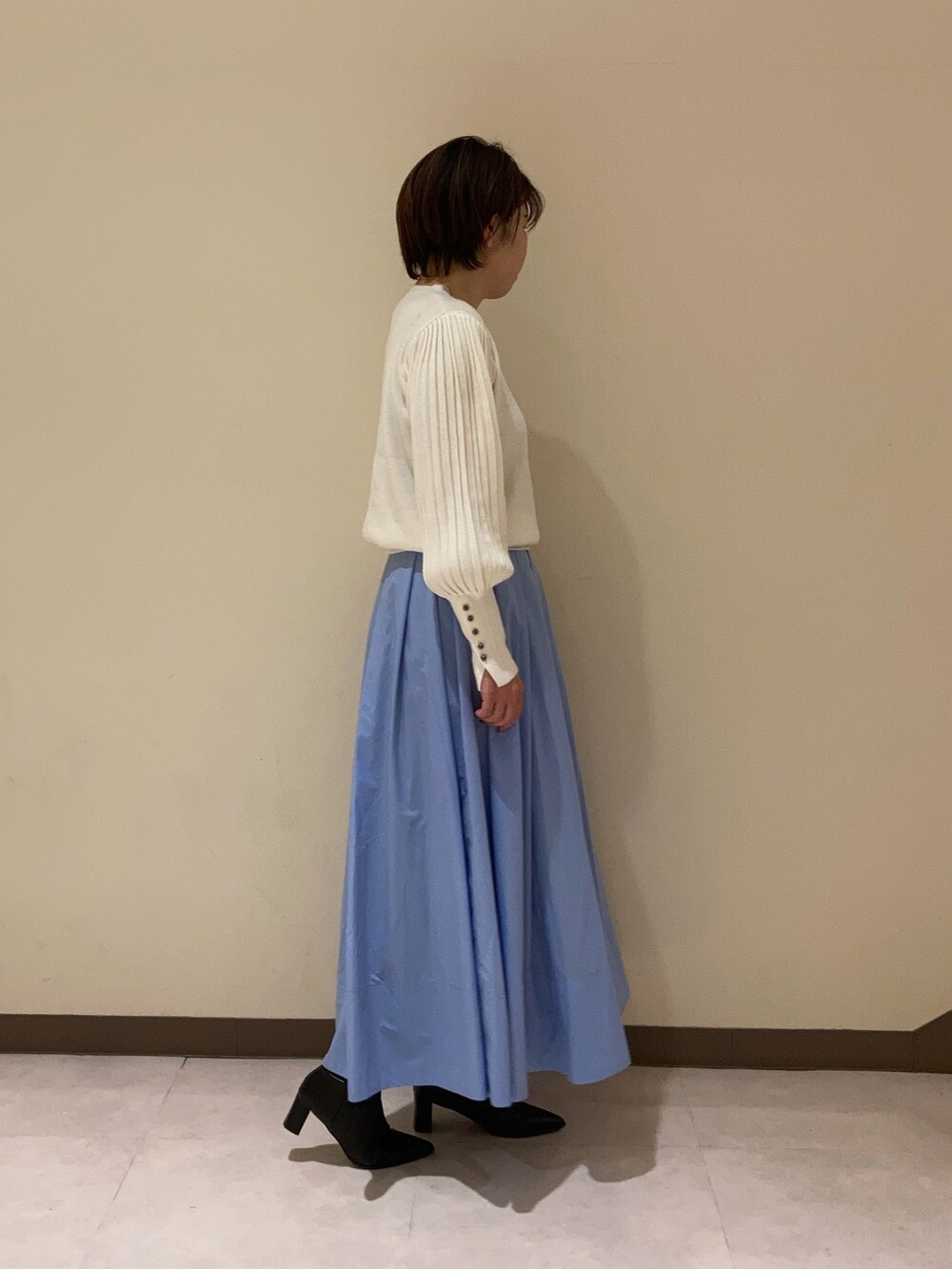 ホワイト系のニット/セーター、ブルー系のスカートを着用したレディースの冬コーディネートの3枚目の写真