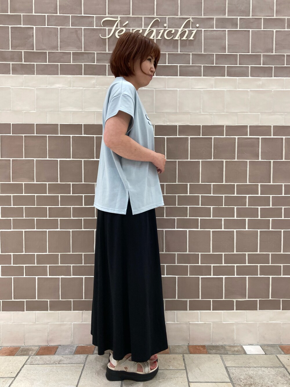 ブルー系のTシャツ/カットソー、ブラック系のスカートを着用したレディースの夏コーディネートの4枚目の写真