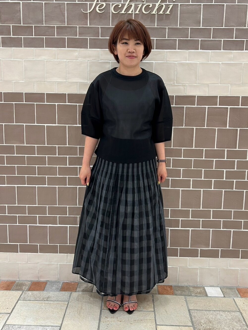 ブラック系のシャツ/ブラウス、ブラック系のスカート、シルバー系のハンドバッグを着用したレディースの春コーディネートの4枚目の写真