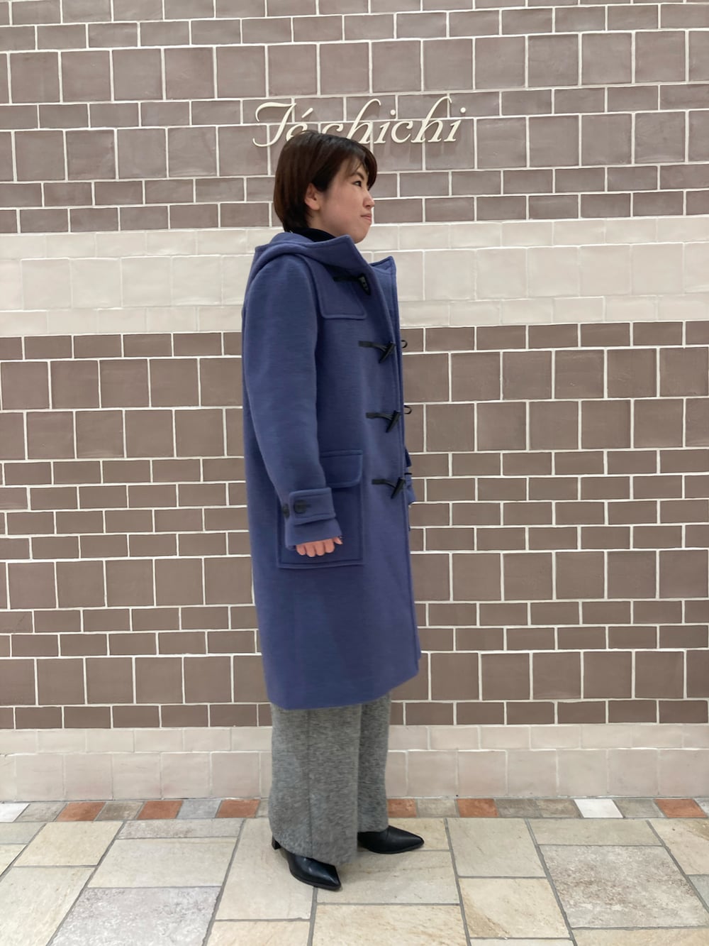 ブルー系のダッフルコートを着用したレディースの冬コーディネートの2枚目の写真