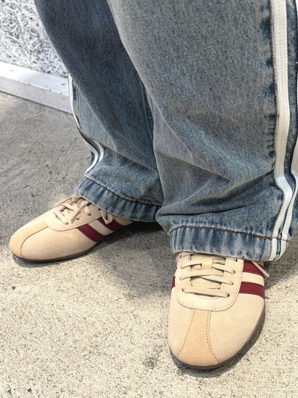 ブルー系のデニムジャケット、ブルー系のデニムパンツ、ベージュ系のショルダーバッグを着用したレディースの春コーディネートの4枚目の写真