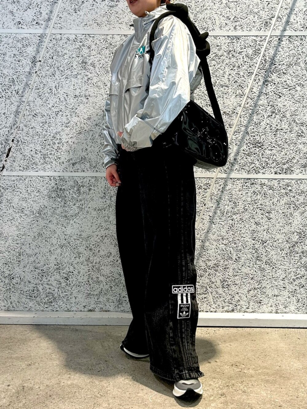 シルバー系のジャケット/アウター、ブラック系のショルダーバッグを着用したレディースの冬コーディネートの2枚目の写真