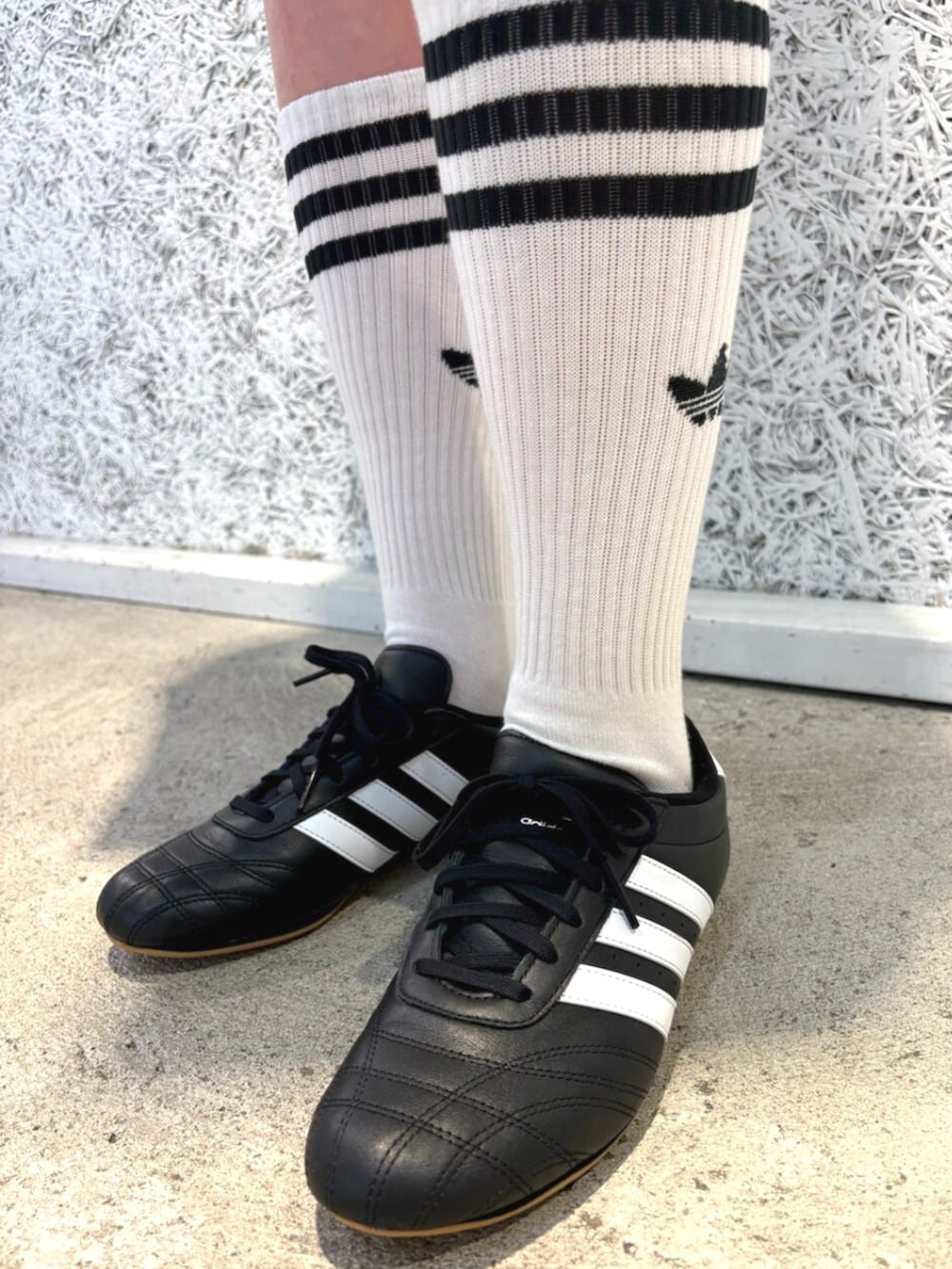 ブラック系のスニーカー、ホワイト系のトップス、ブルー系のデニムスカートを着用したレディースの夏コーディネートの4枚目の写真