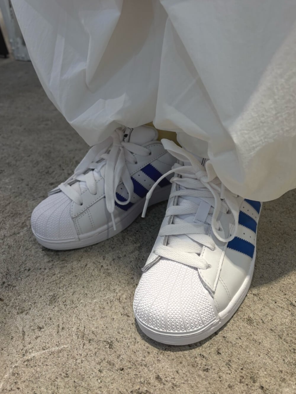 ブラック系のTシャツ/カットソー、ホワイト系のスニーカー、ホワイト系のその他パンツを着用したレディースの春コーディネートの4枚目の写真