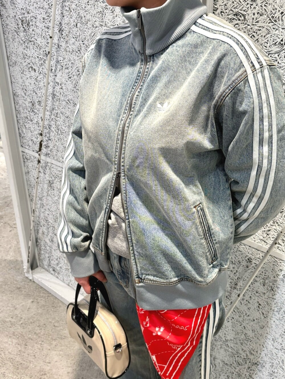 ブルー系のデニムジャケット、ブルー系のデニムパンツ、ベージュ系のショルダーバッグを着用したレディースの春コーディネートの2枚目の写真