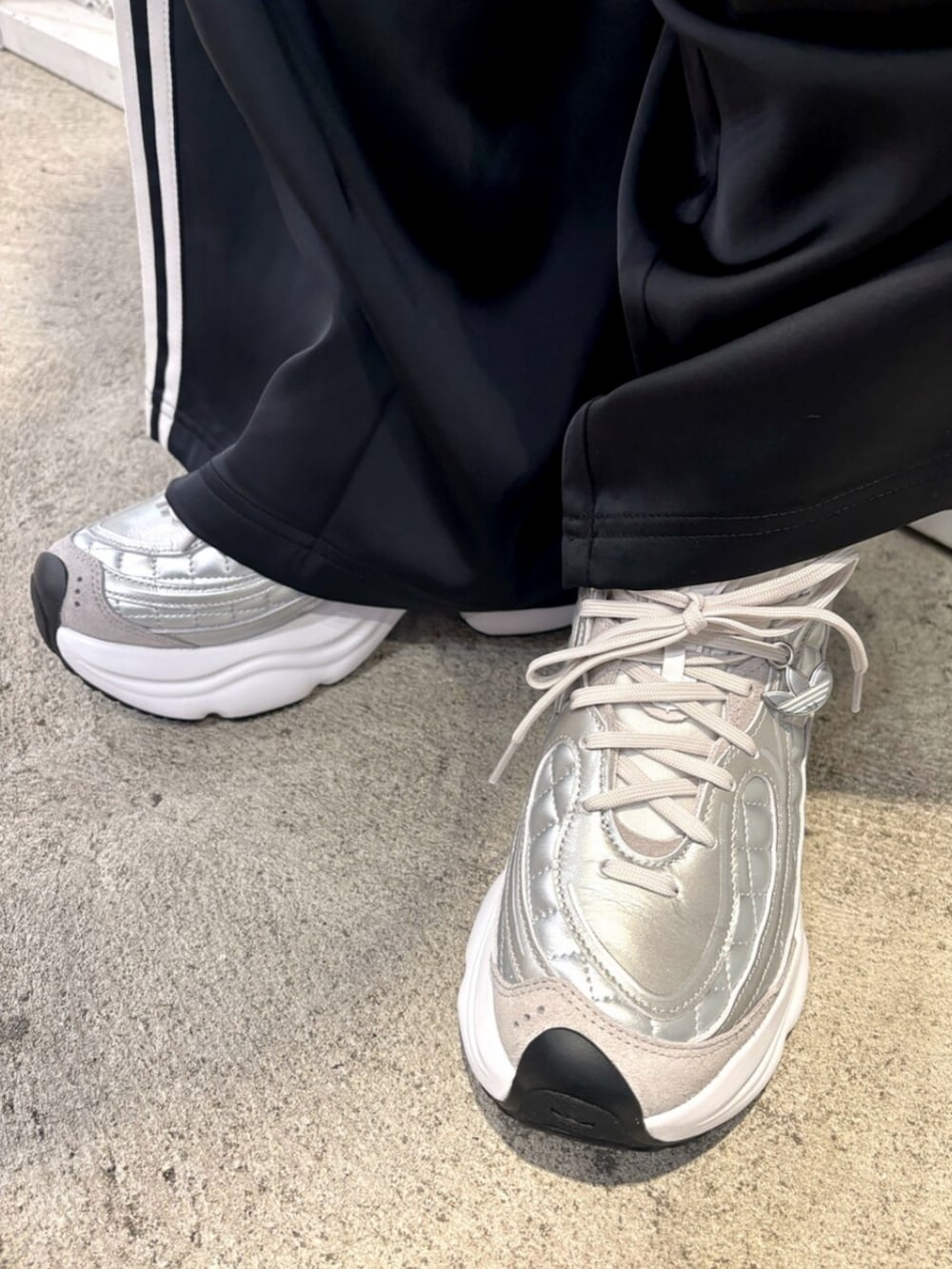 ホワイト系のダウンジャケット/コート、ブラック系のスウェットパンツ、グリーン系のニット/セーターを着用したレディースの冬コーディネートの4枚目の写真