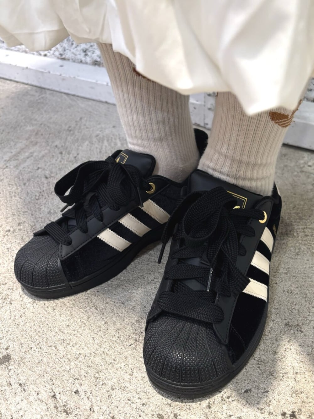 ブラウン系のその他アウター、ホワイト系のスカート、ブラック系のスニーカーを着用したレディースの冬コーディネートの4枚目の写真