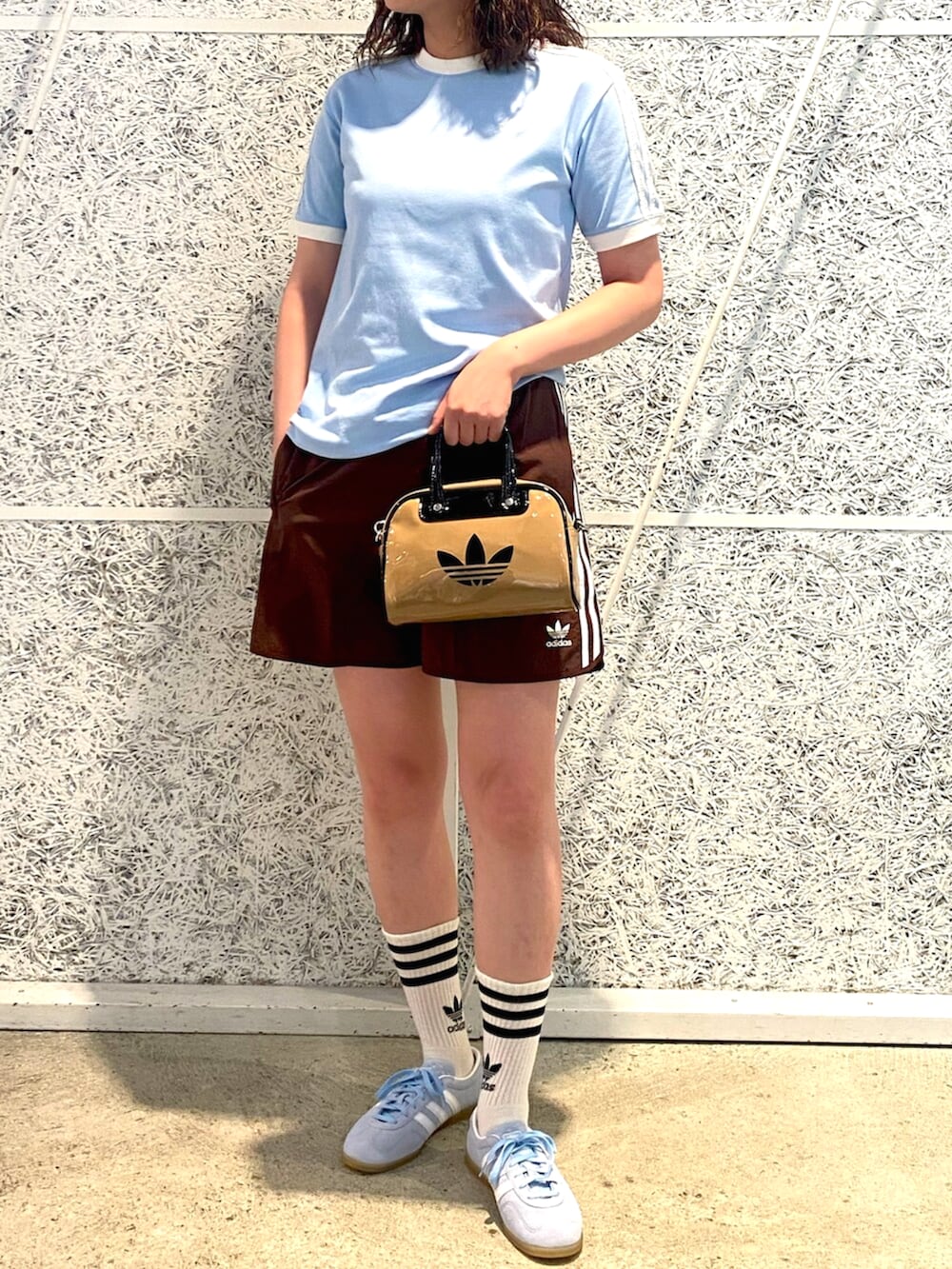 ブルー系のTシャツ/カットソー、ベージュ系のショルダーバッグ、ブルー系のスニーカーを着用したレディースの夏コーディネートの2枚目の写真